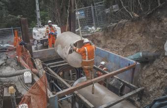Crew lowering concrete pipe